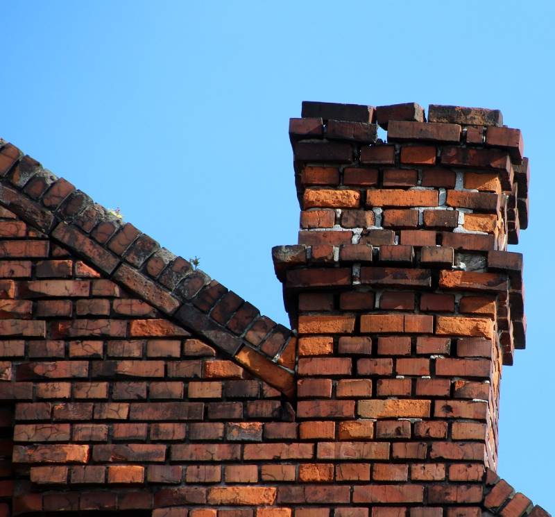 Damaged chimney on an Somerville home showing cracks and missing mortar